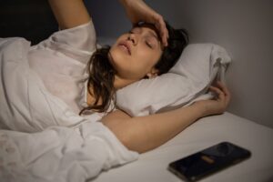 Müde Person im Bett, die sich nach dem Aufwachen erschöpft fühlt